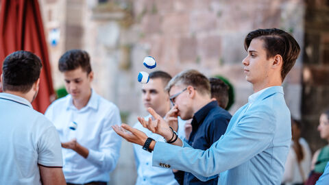 Ein Anwärter wirft zwei Jonglierbälle in die Luft