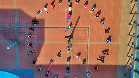 Drohnenaufnahme von Menschen in Form des Peace-Zeichens