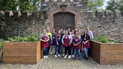 Eine Personengruppe steht zwischen zwei Hochbeeten.