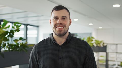 Jens ist ein junger Mann mit kurzen, braunen Haaren und trägt ein dunkelgrün kariertes Hemd.