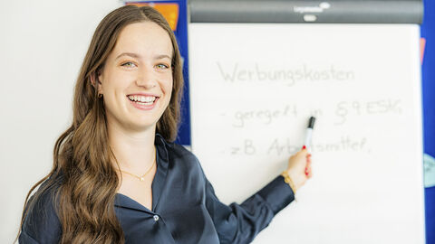 Eine Dozentin präsentiert auf einem Flipchart